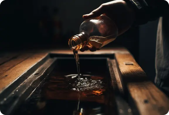 A person pouring whiskey into a bottle.